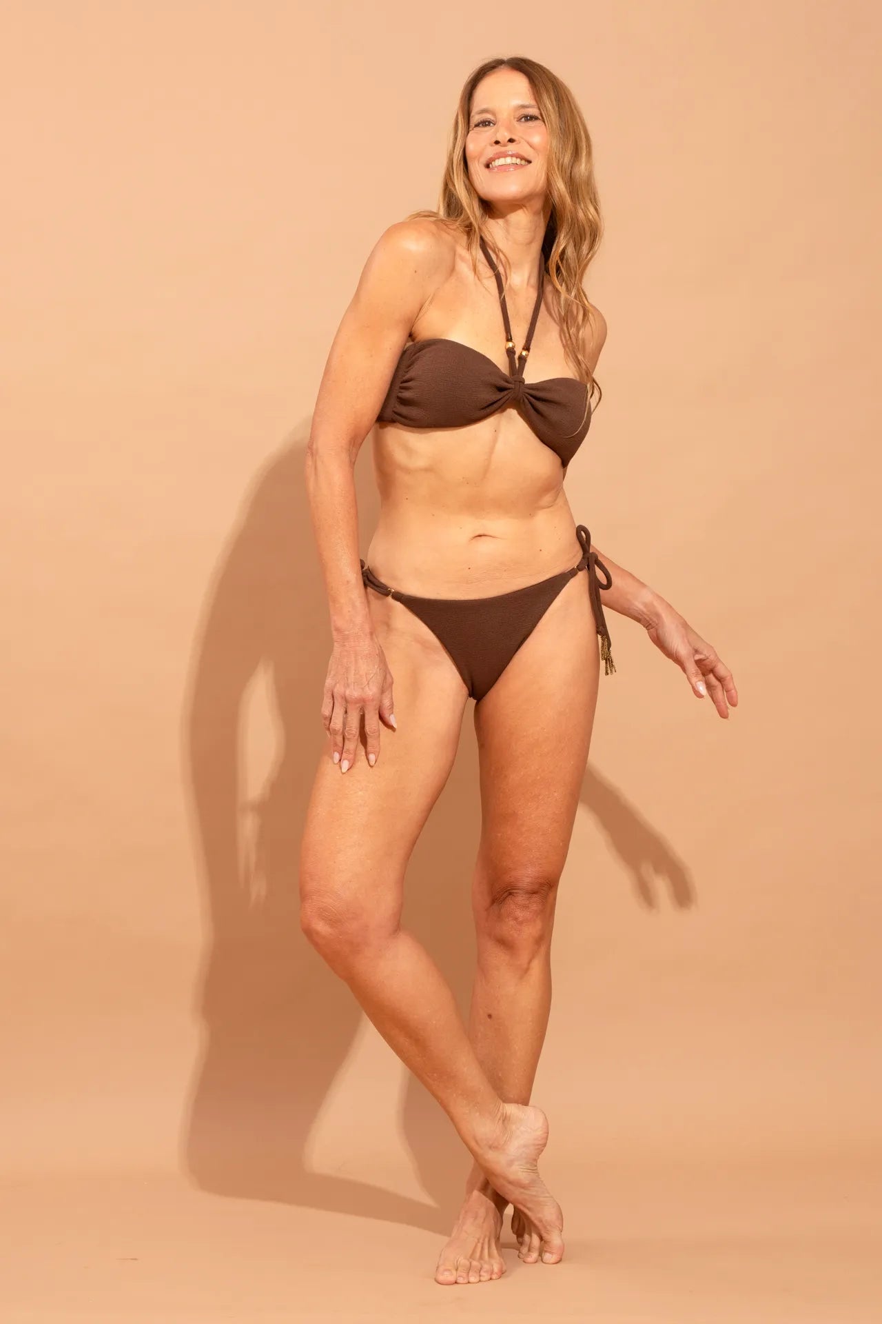 Fotografia de biquíni Carla confeccionado em tecido com textura tátil na cor marrom quente, peças com modelagem anatômica e resistente, marca Isa Rodrigues Resortwear.