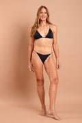 Fotografia de biquíni estruturado Juju na cor preta lisa, top com aro de sustentação e detalhes franzidos no busto, tiras largas confortáveis, marca Isa Rodrigues Resortwear. Frente