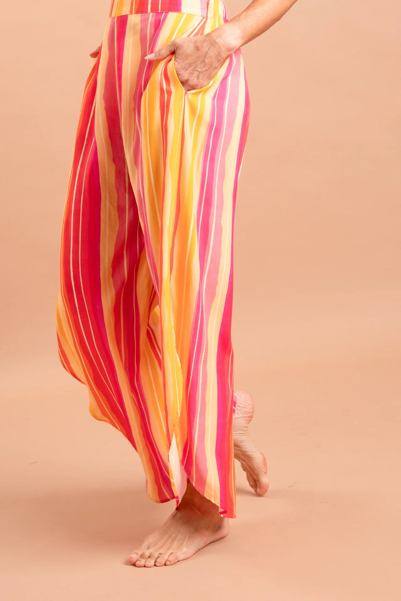 Fotografia de calça feminina ampla com padronagem autoral Estampa Solar, modelagem easy chic com cós liso e fluidez nas pernas, marca Isa Rodrigues Resortwear. Foto detalhe
