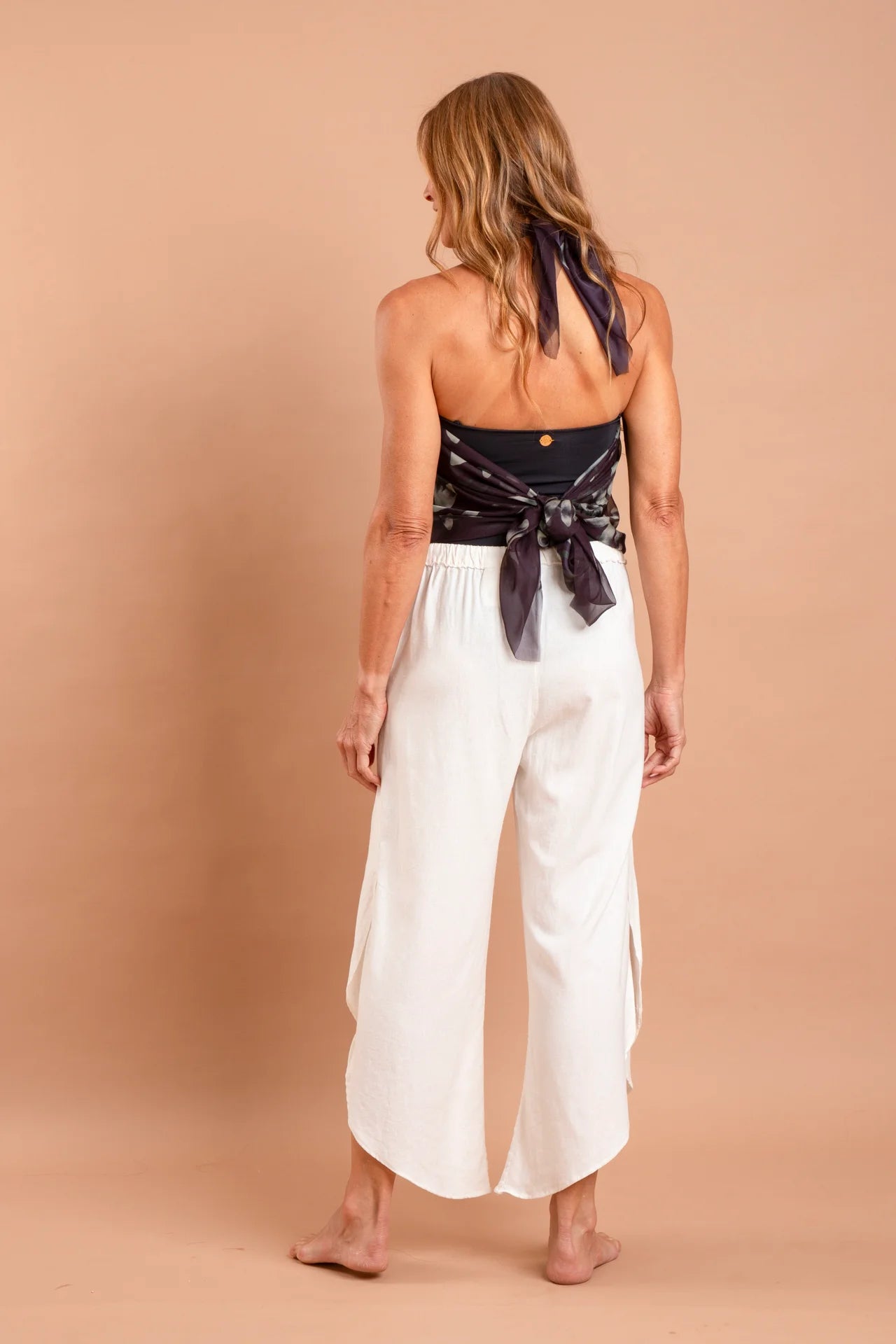 Fotografia de calça feminina ampla de linho misto na cor sla, detalhe de abertura nas pernas e bainha arredondada, estilo easy chic, marca Isa Rodrigues Resortwear. Foto costa