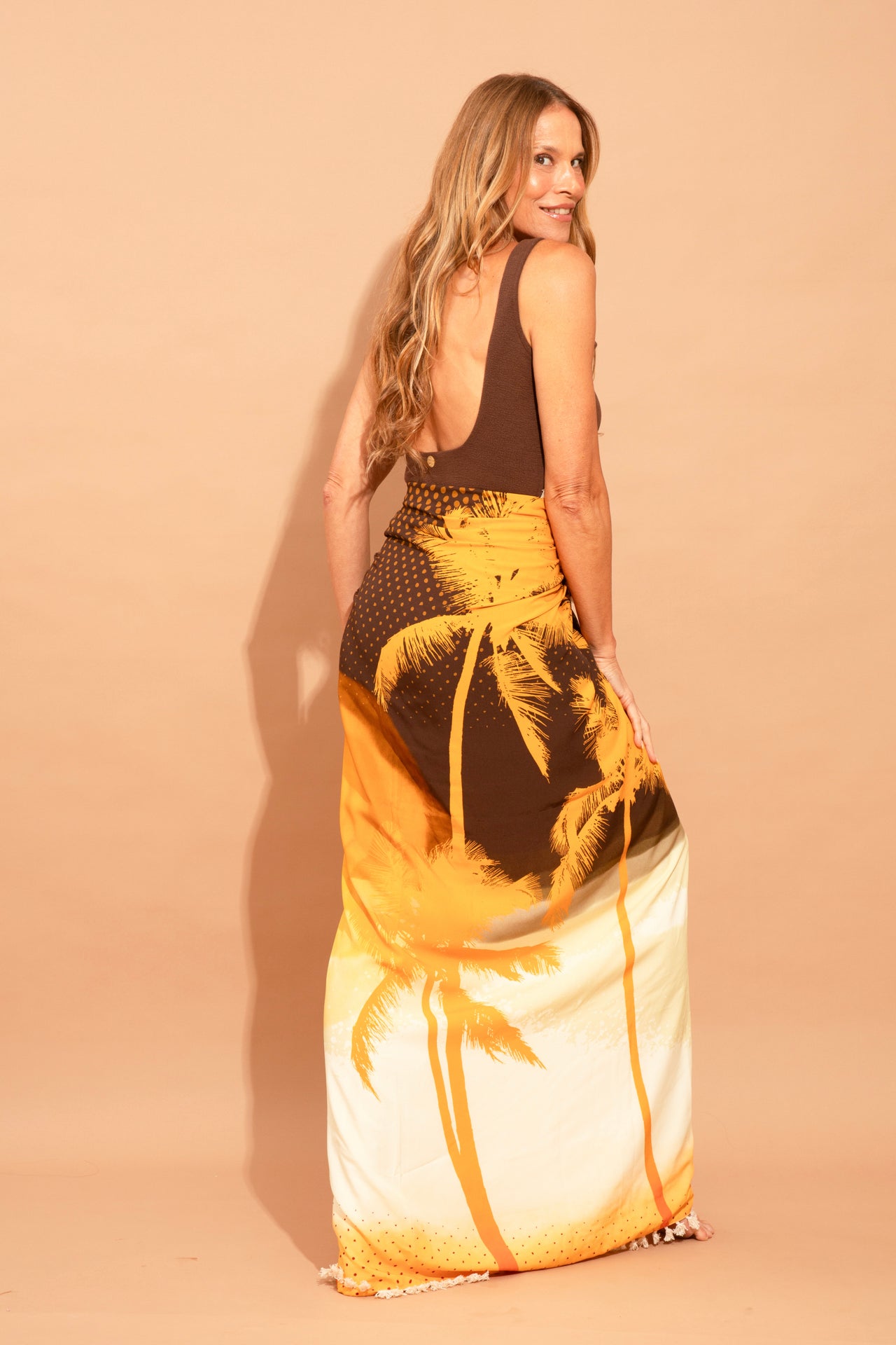 Fotografia de canga de praia premium grande de 1,40x1,40m lisa na cor duna bege claro, feita inteiramente de viscose com toque macio e bordas limpas, marca Isa Rodrigues Resortwear. Costa